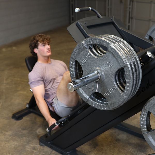 Executing controlled lower body presses using a plate loaded commercial leg press machine